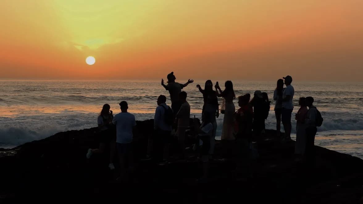 Surfer walking along a Moroccan beach at sunset